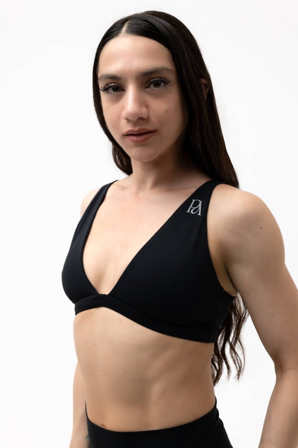 Front close-up model showcase of black sports bra showing perfect fit and construction details for petite women